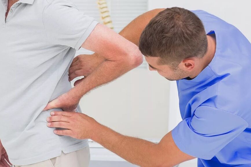 A patient with back pain at a diagnostic examination by a doctor